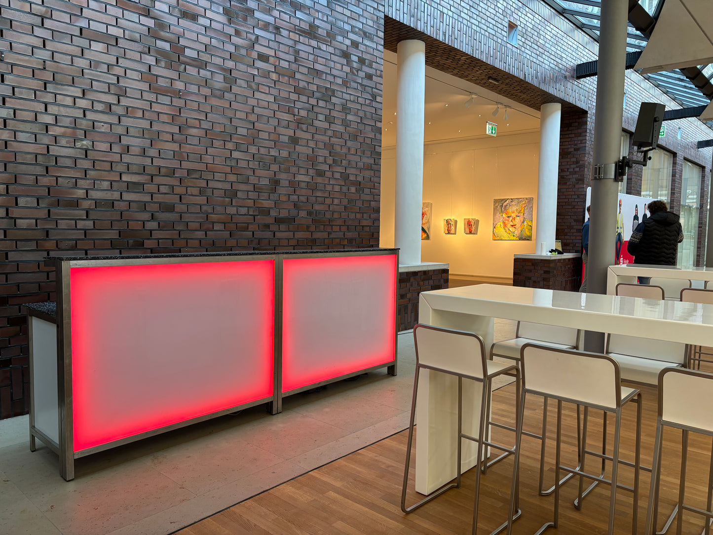 LED-Klapp-Tresen mit roter Beleuchtung im Einsatz bei einer Business-Veranstaltung – stilvolle Thekenlösung mit Edelstahlgestell und Milchglasfront.