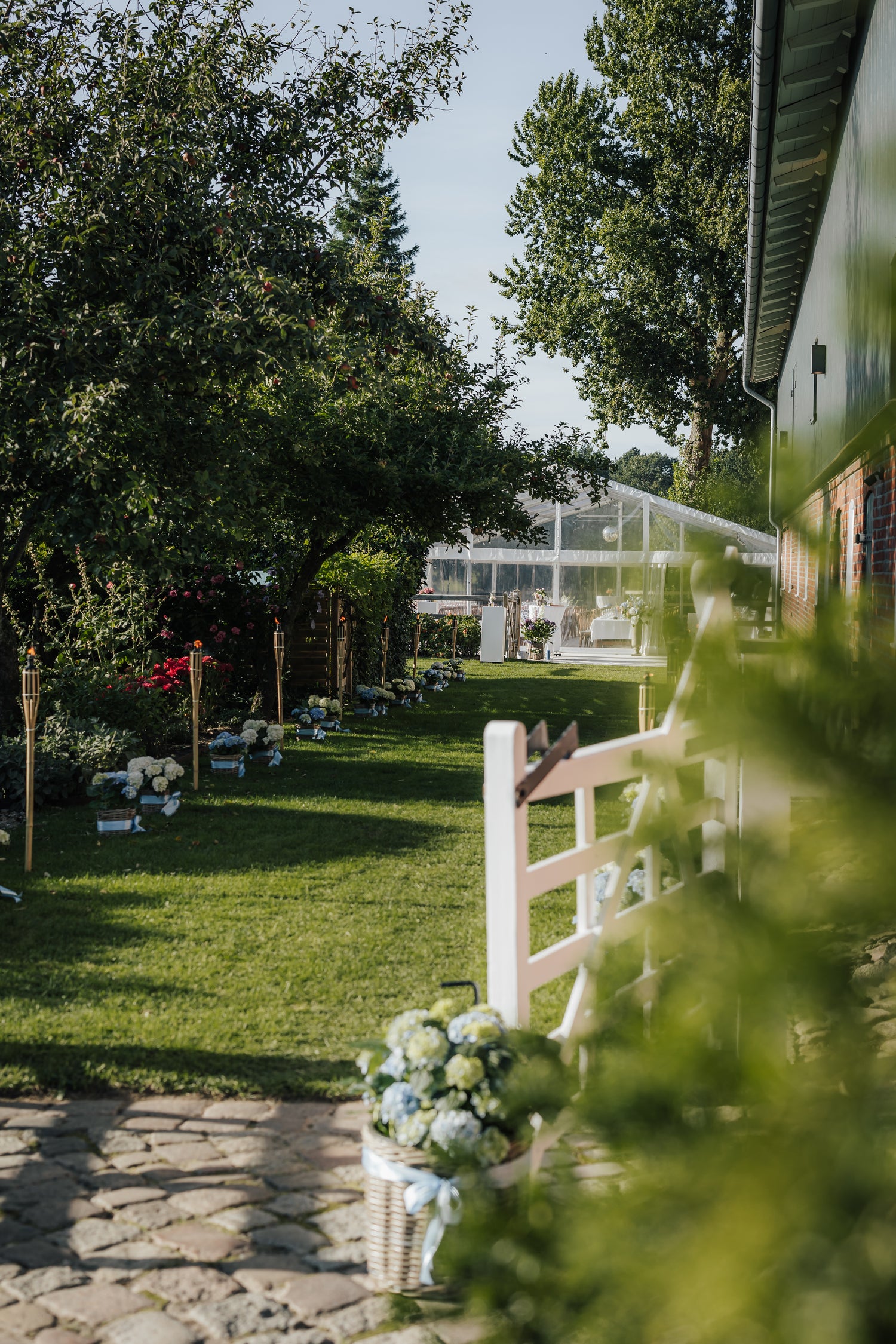 Hochzeitslocation mit dekoriertem Gartenweg und aufgebautem Festzelt für eine Veranstaltung mit gemieteter Eventausstattung vom Eventverleih Schleswig-Holstein