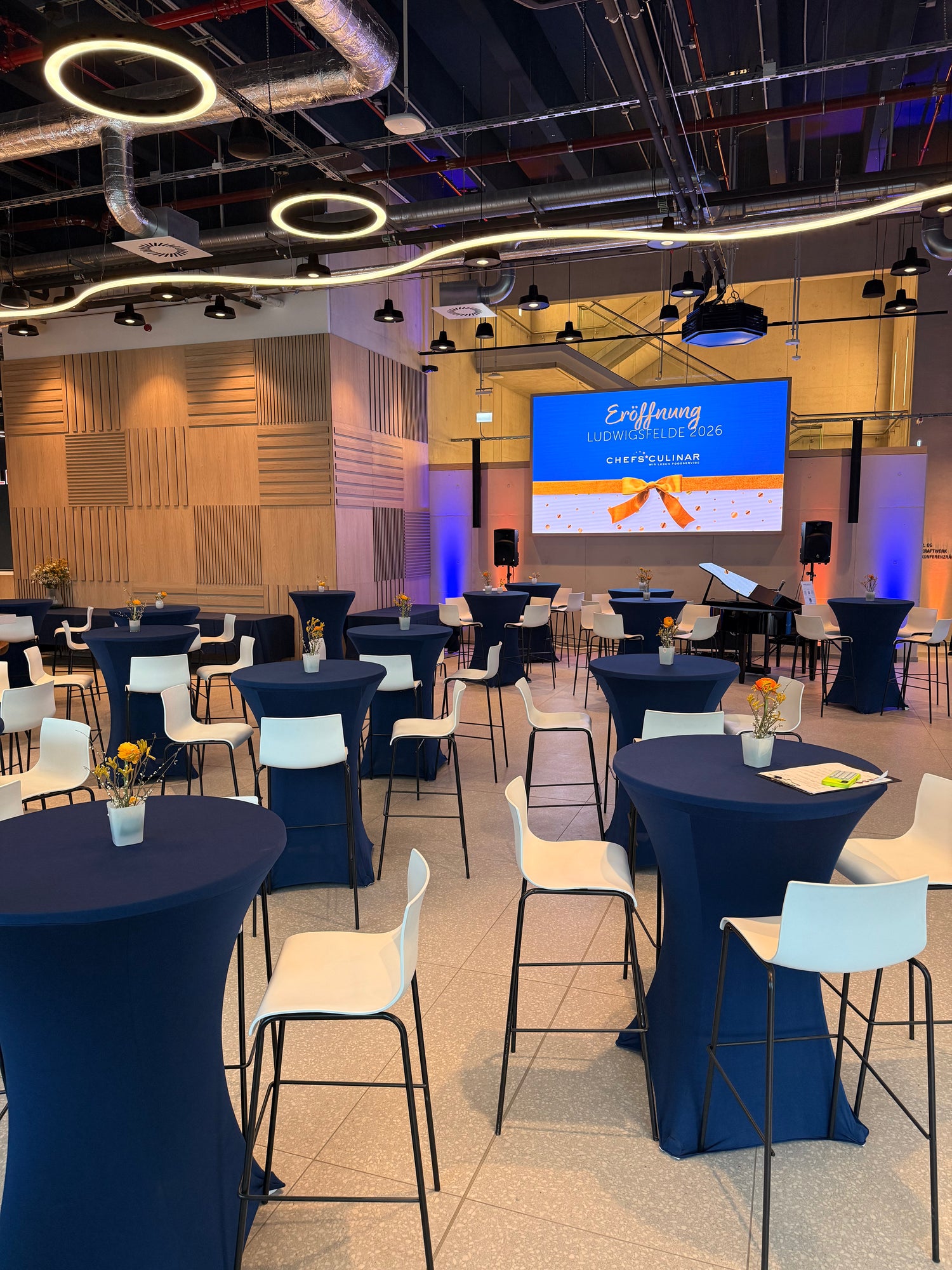 Stehtische mit dunkelblauen Stehtischhussen bei einer Eventveranstaltung, elegante Eventausstattung mit Stehtischhussen für Empfänge, Firmenfeiern und Galas