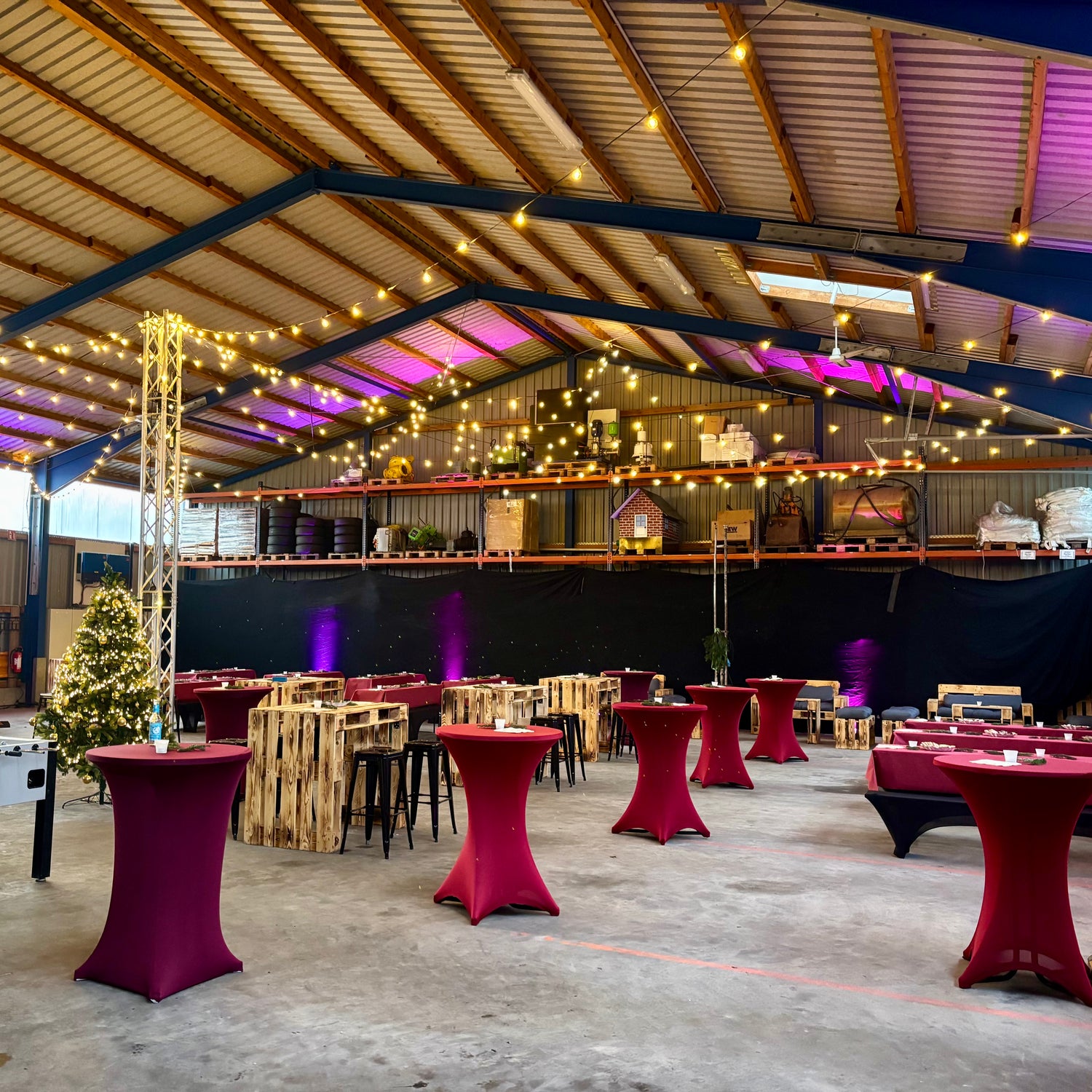 Stehtische mit roten Stretch-Stehtischhussen bei einer Veranstaltung in Eventhalle, elegante Eventausstattung für Firmenfeiern, Empfänge und Events